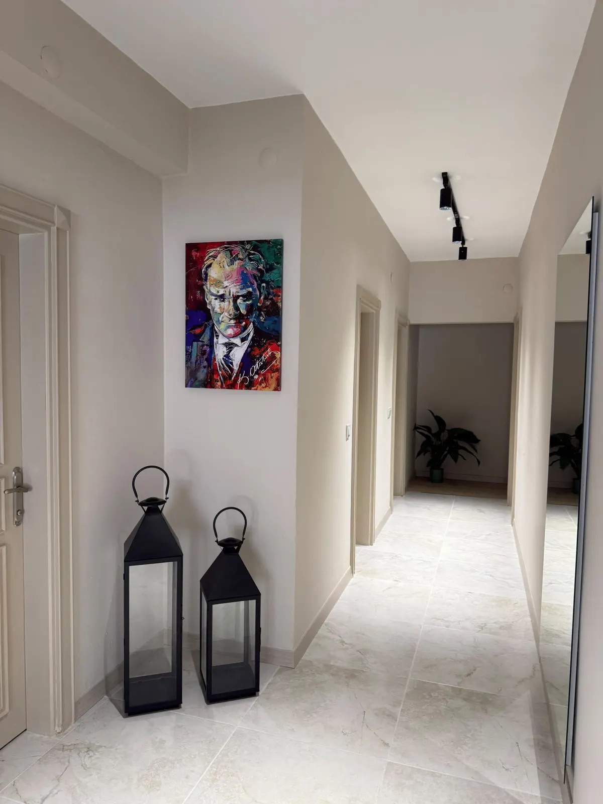 Fenerler ve tablo bulunan aydınlık koridor